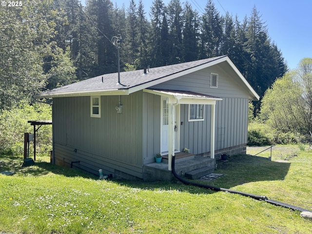 54825 Robinson Rd, Coquille, OR 97423 - view of side of home with a lawn, a wooded view, and a shingled roof