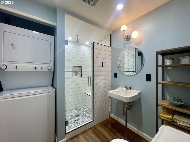 54825 Robinson Rd, Coquille, OR 97423 - bathroom with stacked washer / drying machine, a shower stall, wood finished floors, recessed lighting, and a sink