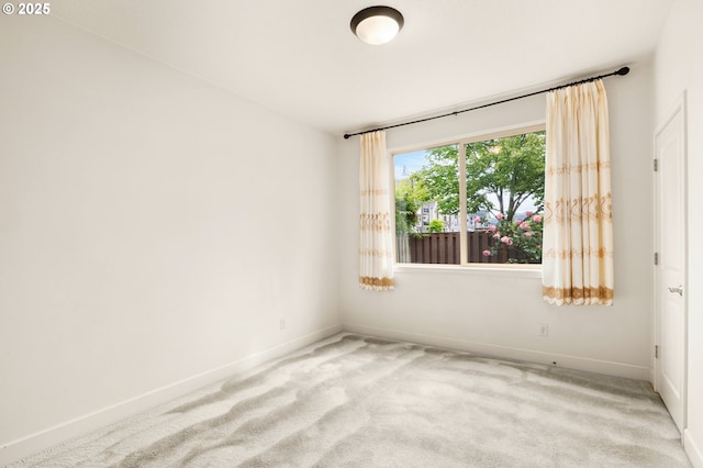 unfurnished room with light carpet and baseboards