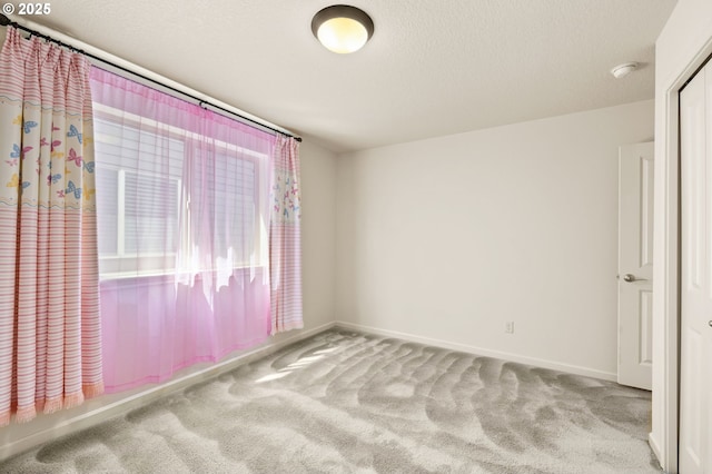 spare room featuring carpet floors, a smoke detector, and baseboards