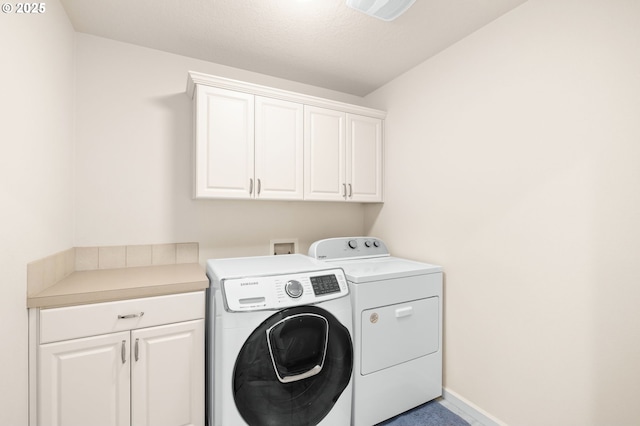 laundry area featuring cabinet space, separate washer and dryer, and baseboards