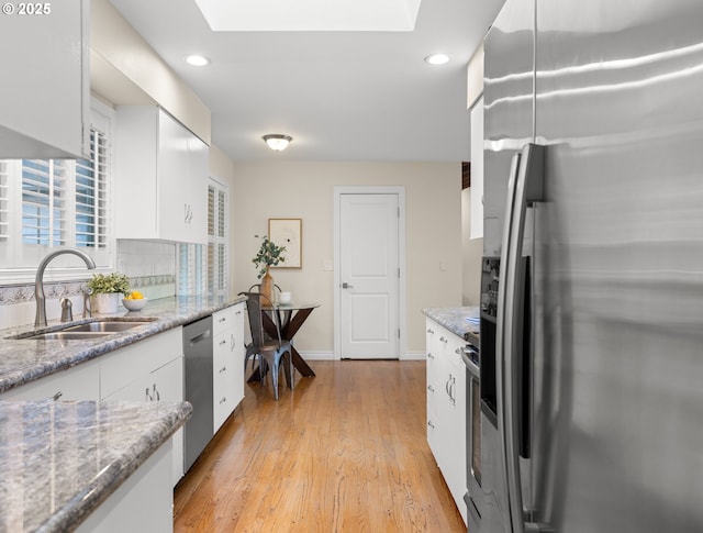 13920 Shireva Dr, Lake Oswego, OR 97034 - kitchen with stainless steel appliances, a skylight, white cabinetry, and recessed lighting