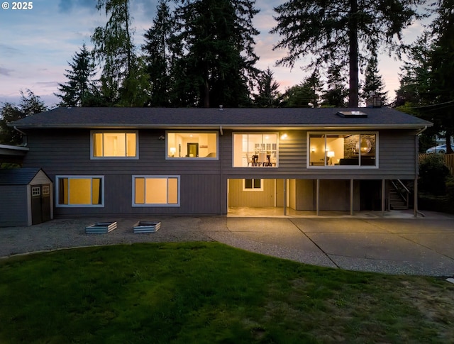 13920 Shireva Dr, Lake Oswego, OR 97034 - back of property at dusk with a patio, a storage unit, a yard, and stairs