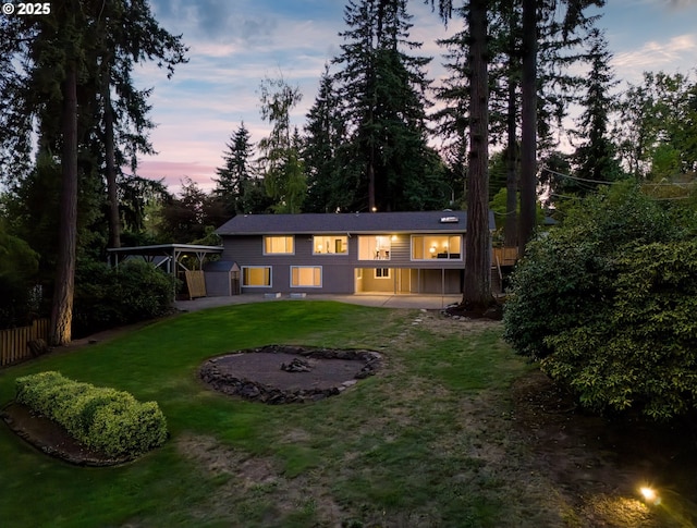 13920 Shireva Dr, Lake Oswego, OR 97034 - back of property at dusk featuring a patio area, a carport, and a storage unit