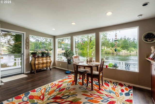 sunroom / solarium with plenty of natural light and a water view