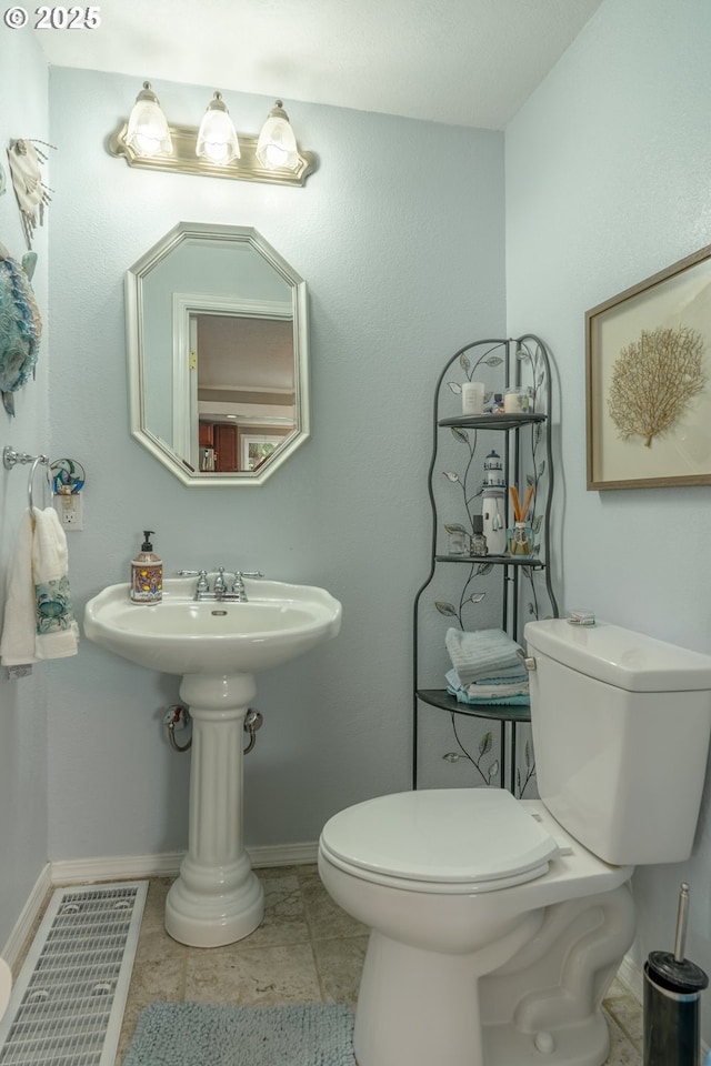 bathroom featuring toilet and baseboards