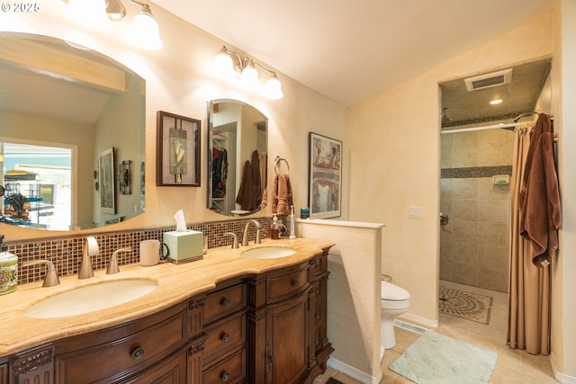 full bath with tiled shower, backsplash, double vanity, tile patterned floors, and toilet