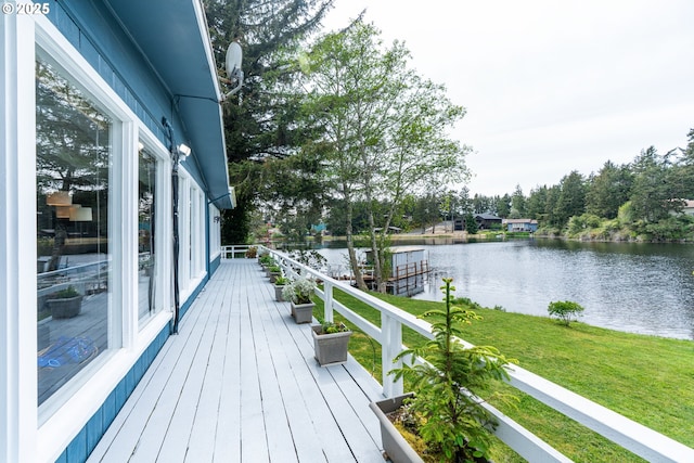 wooden deck with a water view and a lawn