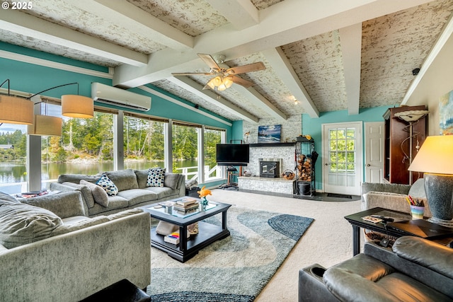 living area with a wall unit AC, carpet floors, a stone fireplace, a ceiling fan, and a water view