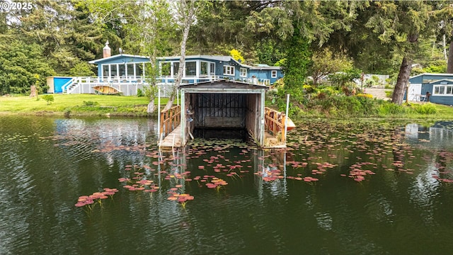 dock area with a water view, a yard, and a forest view