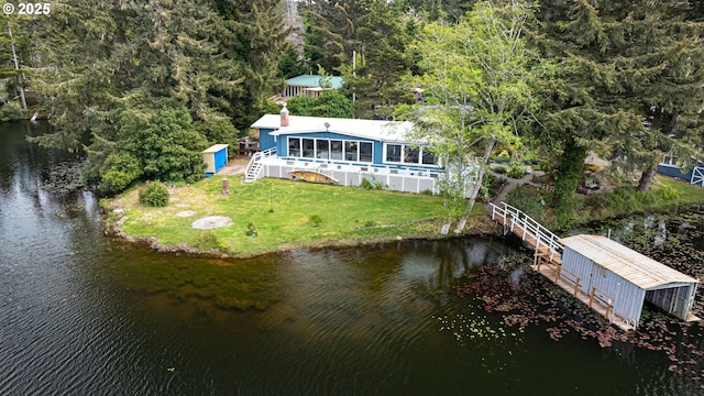 aerial view of property and surrounding area featuring a large body of water and a heavily wooded area