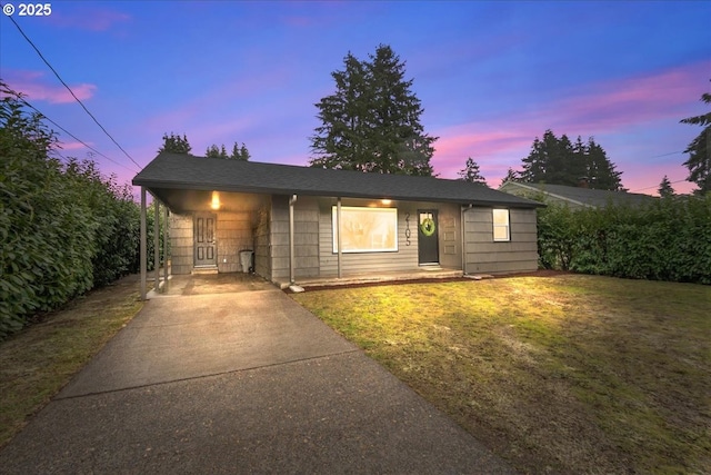 view of front of property featuring a carport and a yard