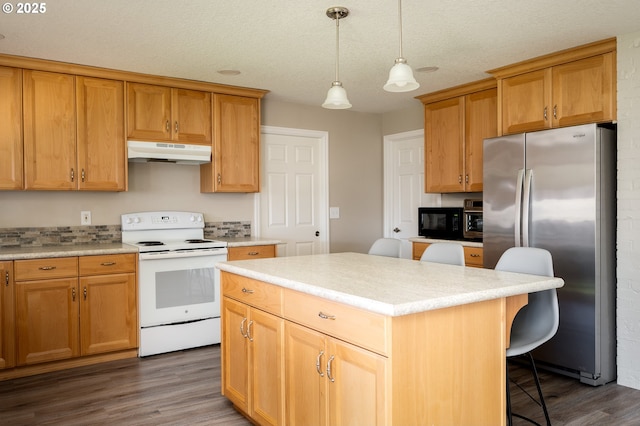 kitchen featuring a breakfast bar area, white range with electric cooktop, freestanding refrigerator, black microwave, and under cabinet range hood