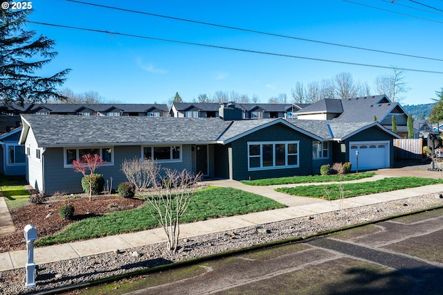 ranch-style house featuring driveway, a garage, a residential view, roof with shingles, and a front yard