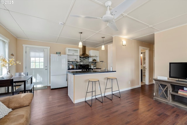 419 State St, Lyle, WA 98635 - kitchen with dark countertops, dark wood finished floors, wall chimney range hood, stove, and freestanding refrigerator