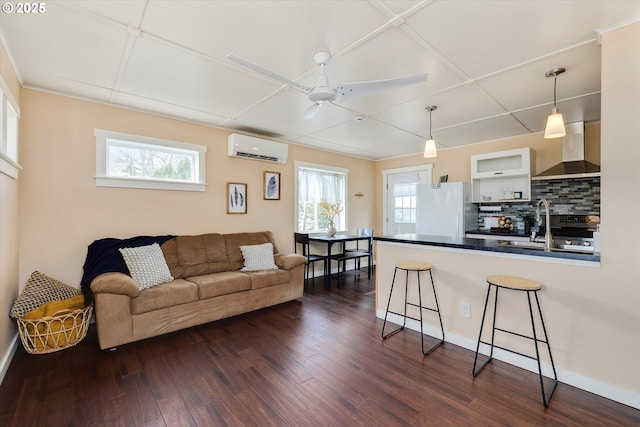 419 State St, Lyle, WA 98635 - living area featuring dark wood-style flooring, a wall unit AC, a healthy amount of sunlight, and ceiling fan
