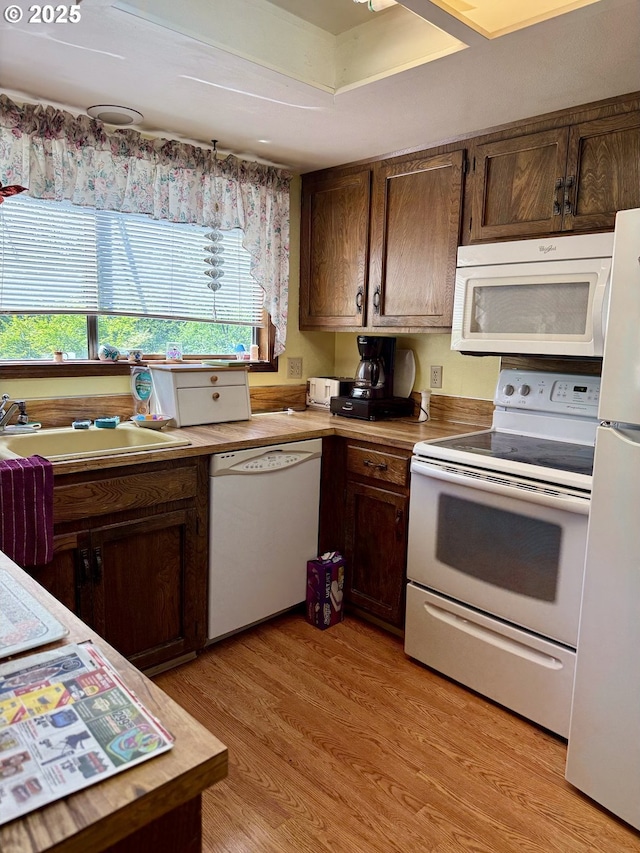 275 NE Scott Dr, Gresham, OR 97030 - kitchen featuring white appliances, a sink, light wood-style flooring, and dark brown cabinets