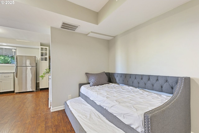 bedroom featuring freestanding refrigerator, baseboards, visible vents, and dark wood-style floors