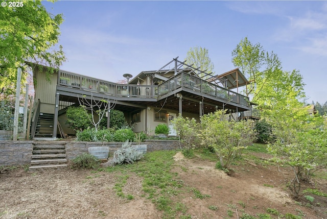 back of property with a wooden deck and stairway