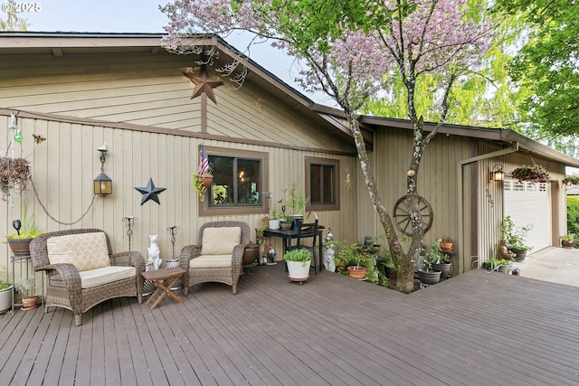 deck featuring an attached garage and driveway
