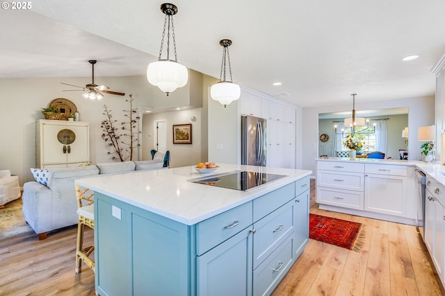 603 Lone Oaks Loop, Silverton, OR 97381 - kitchen featuring black electric cooktop, open floor plan, freestanding refrigerator, light wood-style flooring, and white cabinets