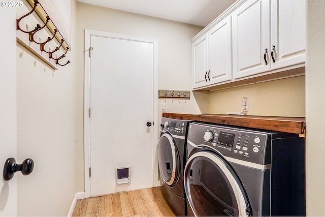 603 Lone Oaks Loop, Silverton, OR 97381 - washroom featuring washing machine and clothes dryer, light wood-type flooring, and cabinet space