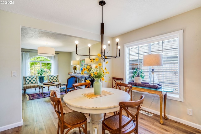 603 Lone Oaks Loop, Silverton, OR 97381 - dining room featuring hardwood / wood-style floors, a chandelier, and a textured ceiling