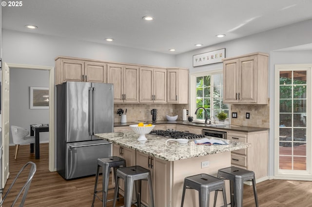 6783 Apollo Rd, West Linn, OR 97068 - kitchen with appliances with stainless steel finishes, light brown cabinetry, a sink, a kitchen bar, and dark wood finished floors