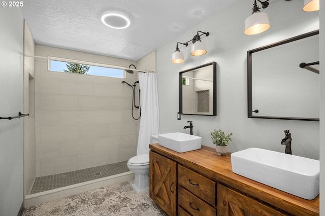 6783 Apollo Rd, West Linn, OR 97068 - full bath featuring a tile shower, toilet, double vanity, a textured ceiling, and tile patterned floors