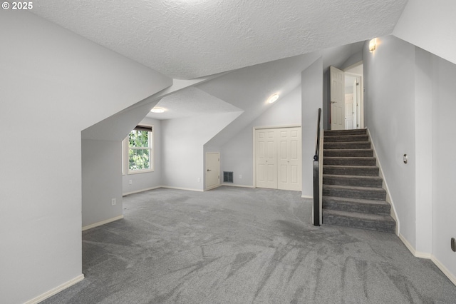 6783 Apollo Rd, West Linn, OR 97068 - bonus room featuring vaulted ceiling, a textured ceiling, carpet flooring, baseboards, and stairway