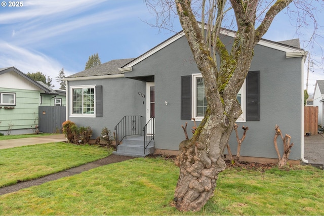 bungalow-style house with a front yard and stucco siding