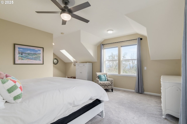 bedroom with ceiling fan, lofted ceiling with skylight, and light carpet