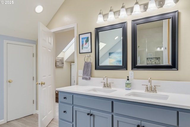 bathroom featuring wood-type flooring, vanity, and lofted ceiling