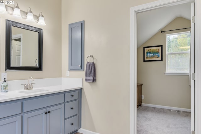 bathroom with vanity and lofted ceiling