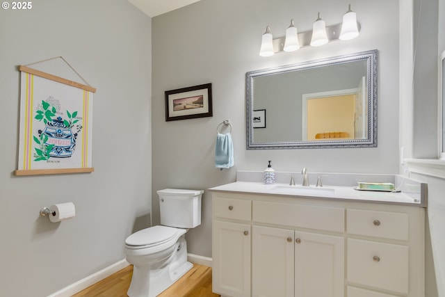 bathroom featuring wood-type flooring, vanity, and toilet