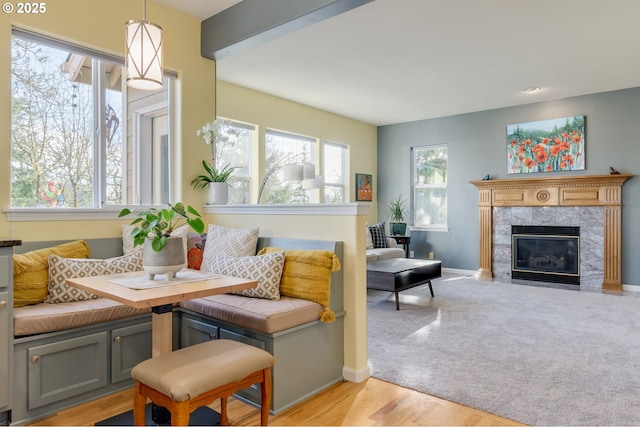 sitting room with breakfast area, a healthy amount of sunlight, a fireplace, and light carpet