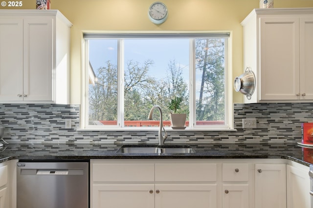 kitchen featuring white cabinetry, stainless steel dishwasher, dark stone countertops, and sink