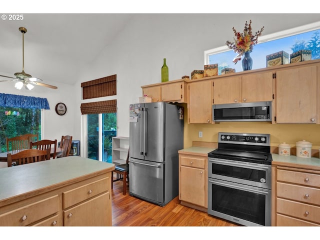 kitchen featuring light brown cabinetry, light countertops, stainless steel appliances, a ceiling fan, and light wood-type flooring