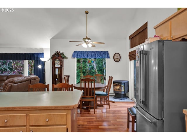 kitchen with a ceiling fan, high end fridge, plenty of natural light, and wood finished floors