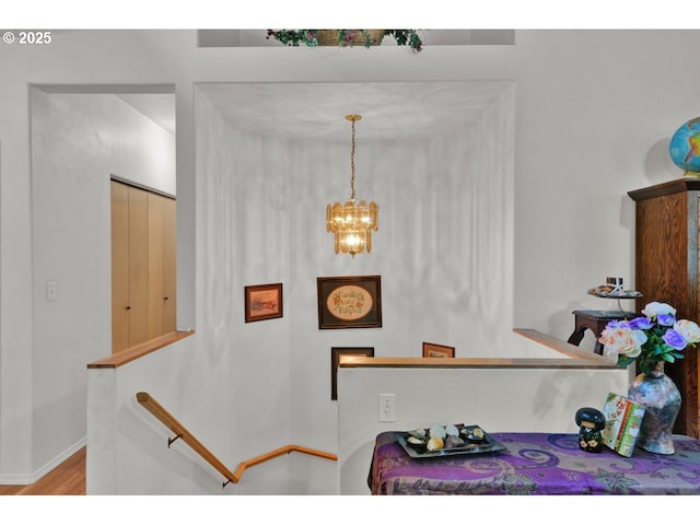 interior space featuring baseboards, wood finished floors, and a chandelier