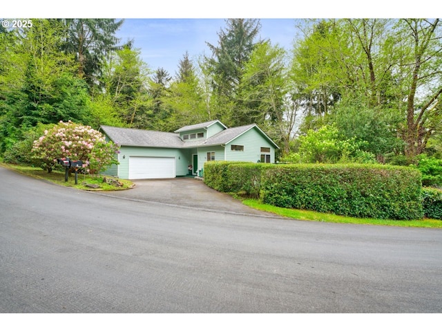 view of front of house featuring an attached garage and aphalt driveway