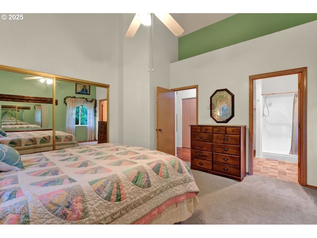 carpeted bedroom with connected bathroom, high vaulted ceiling, ceiling fan, and a closet