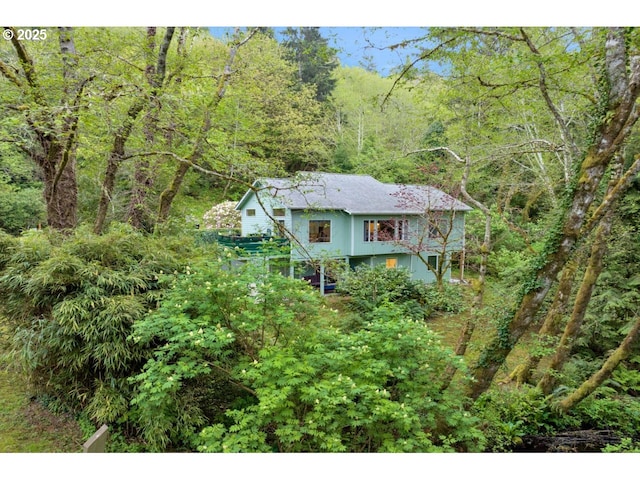 view of front of house featuring a forest view
