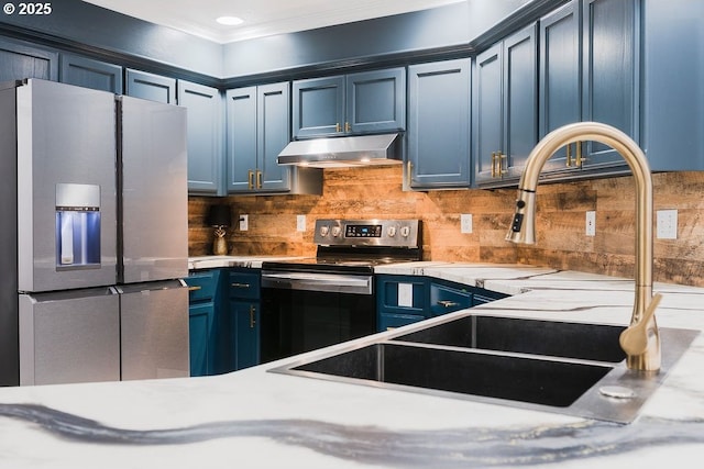 kitchen with blue cabinetry, light countertops, decorative backsplash, appliances with stainless steel finishes, and under cabinet range hood