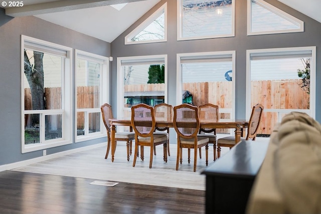 dining room featuring vaulted ceiling, wood finished floors, and visible vents