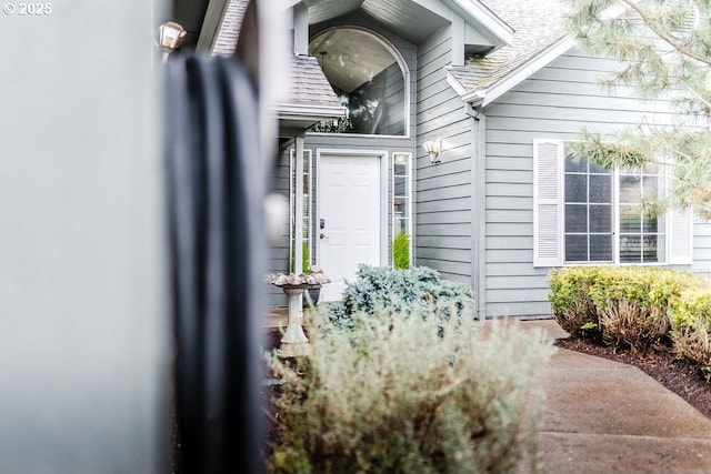 property entrance featuring roof with shingles