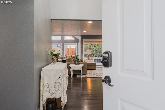 interior space featuring dark wood-style floors, recessed lighting, and a textured wall