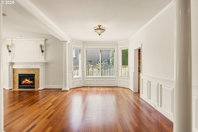 4123 Chad Dr, Lake Oswego, OR 97034 - unfurnished living room with ornate columns, wood finished floors, ornamental molding, a tiled fireplace, and a decorative wall