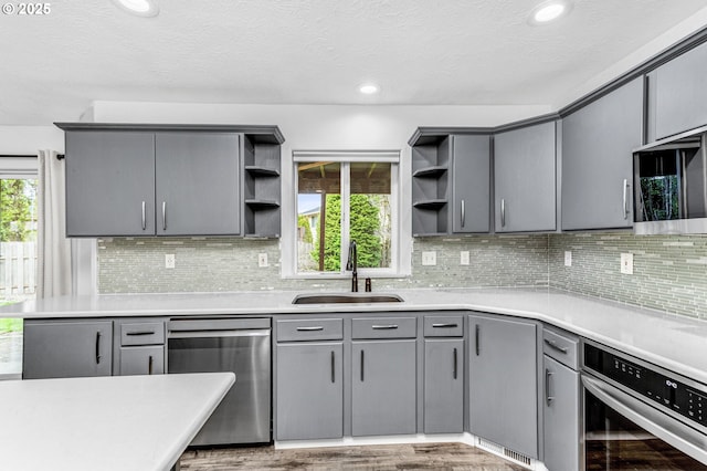 kitchen featuring open shelves, appliances with stainless steel finishes, and gray cabinets