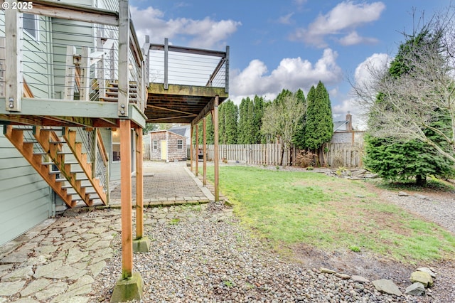 view of yard with a patio, stairway, fence, a shed, and an outdoor structure